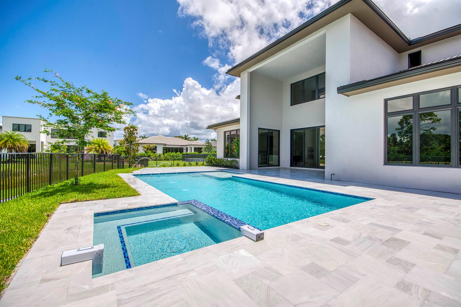 A modern two-story house with a swimming pool, spa, and patio in the backyard — 18409 Symphony Court, Jupiter FL 33458, JUPITER, FL