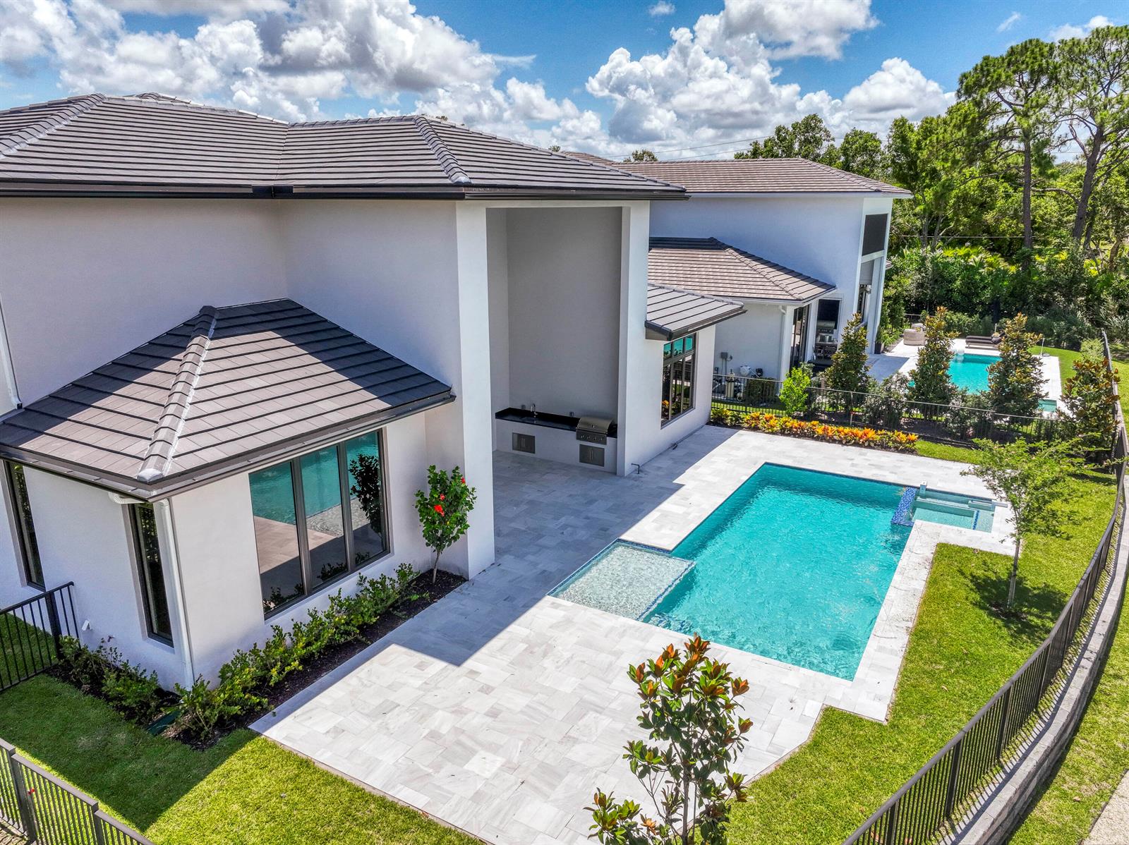 An aerial view of a modern white house with a swimming pool and patio — 18409 Symphony Court, Jupiter FL 33458, JUPITER, FL