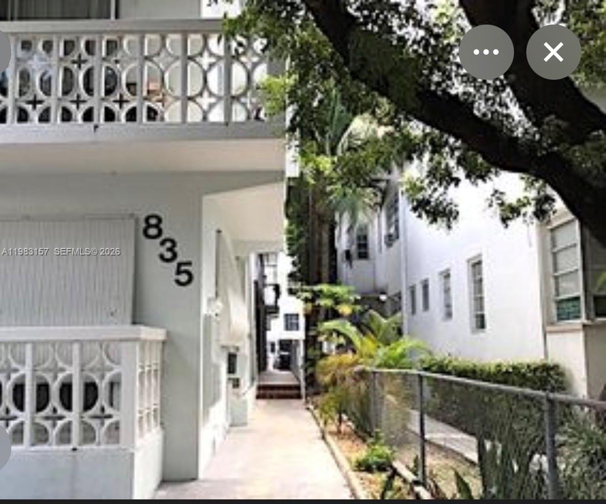 An exterior view of a white apartment building with a decorative balcony and walkway — 835 Meridian Ave # A, Miami Beach FL 33139, MIAMI BEACH, FL