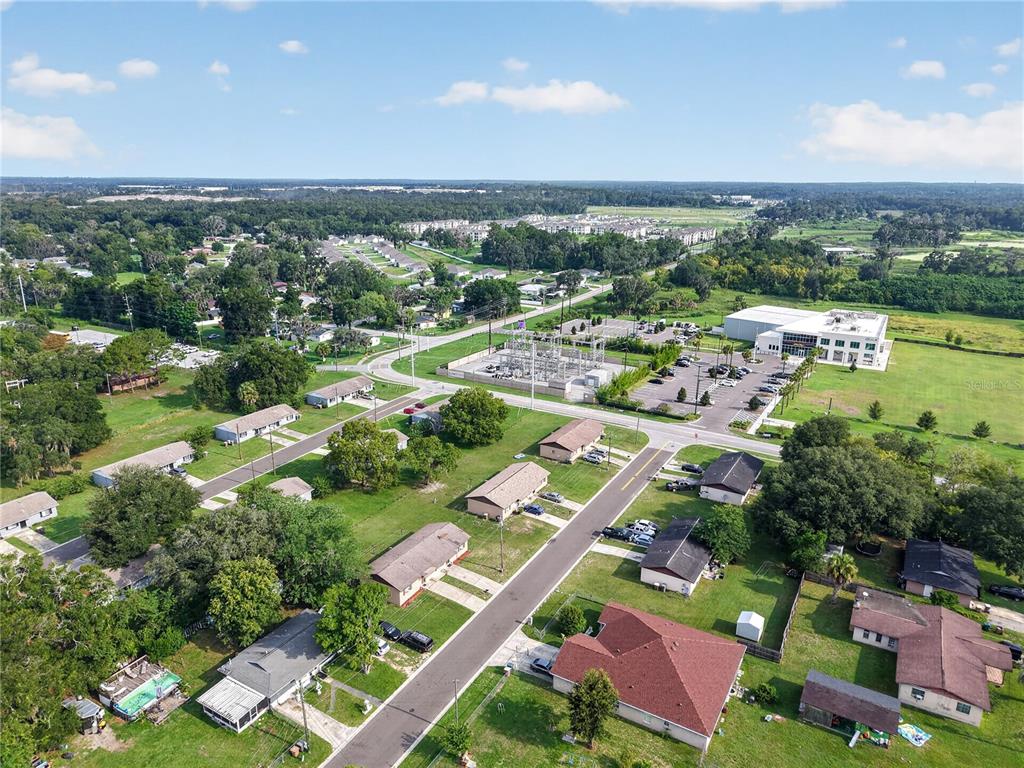 An aerial view shows a residential neighborhood with houses, a power substation, and a commercial building — 1632/1634 NW 20TH COURT, OCALA, FL