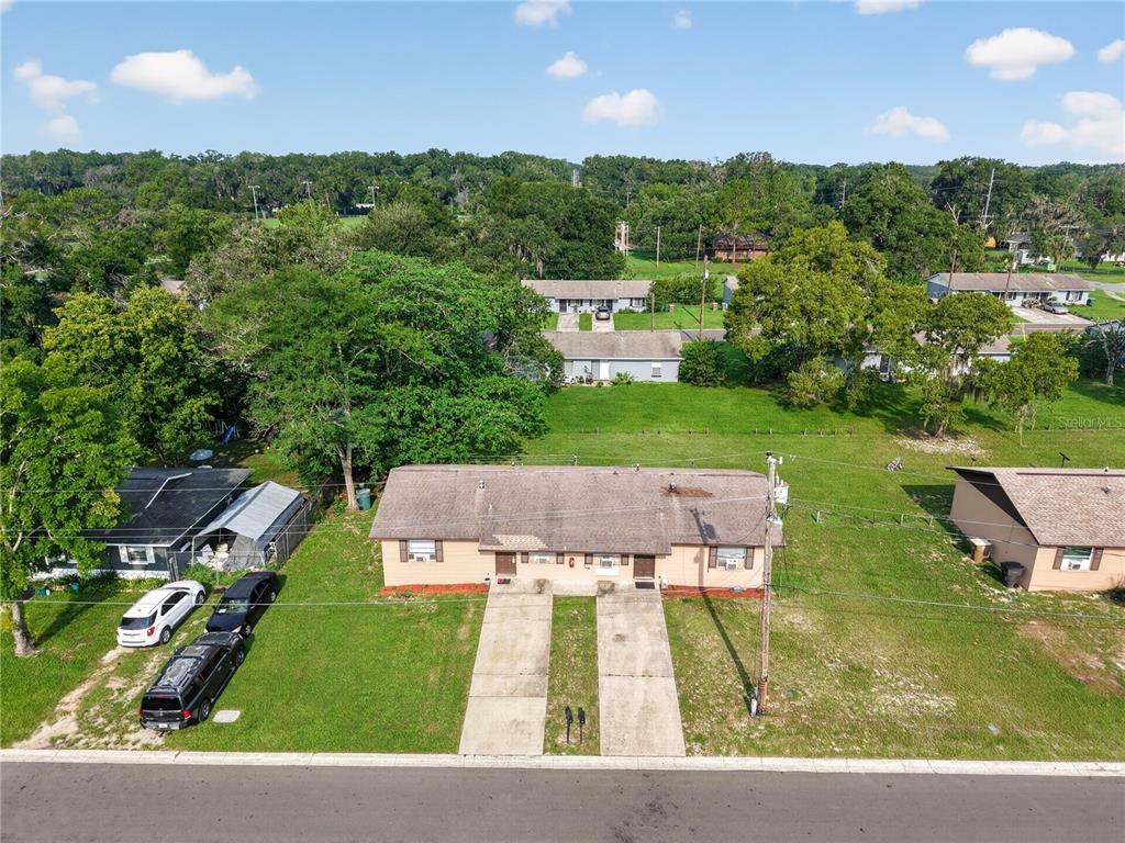 An aerial view of a single-story duplex with a concrete driveway and surrounding grassy yard — 1632/1634 NW 20TH COURT, OCALA, FL