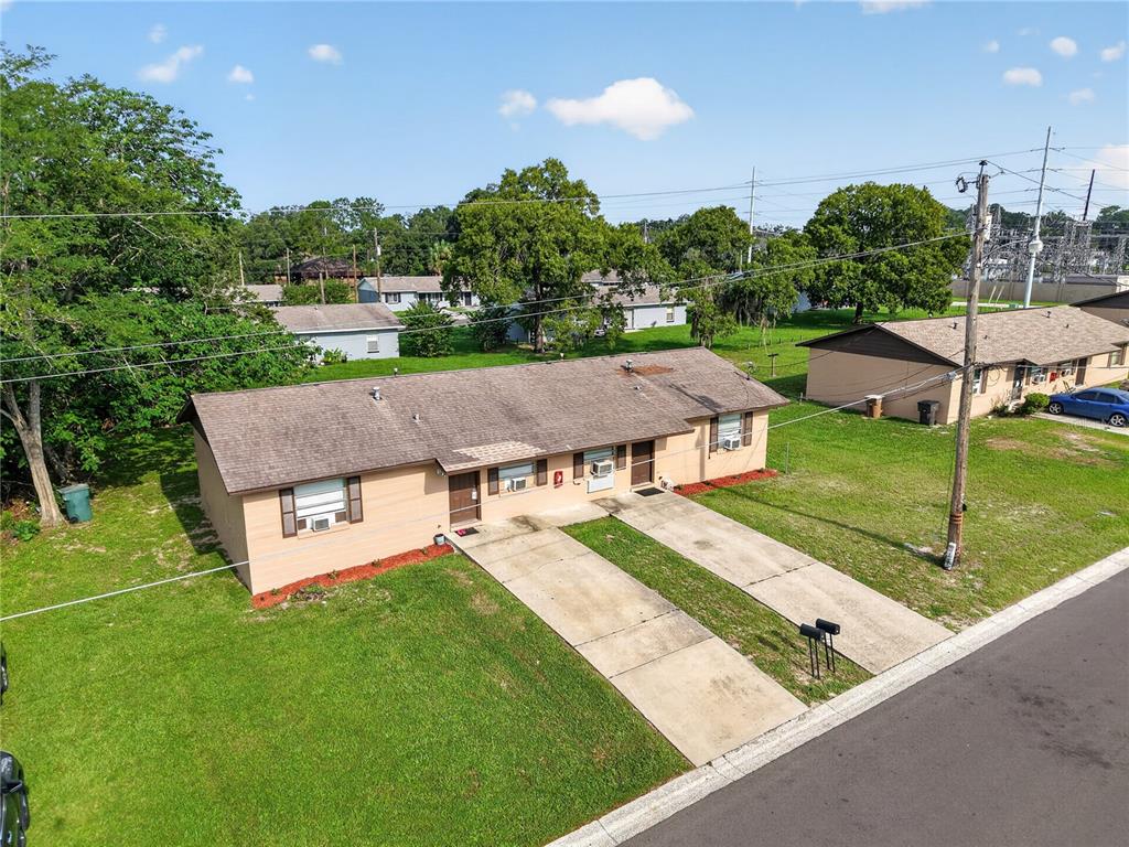 An aerial view of a single-story duplex with two concrete driveways and a grassy yard — 1632/1634 NW 20TH COURT, OCALA, FL