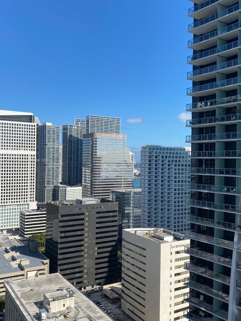 An elevated view of a dense urban skyline featuring multiple high-rise office and residential buildings — 1000 Brickell Plz # 3207, Miami FL 33131, MIAMI, FL