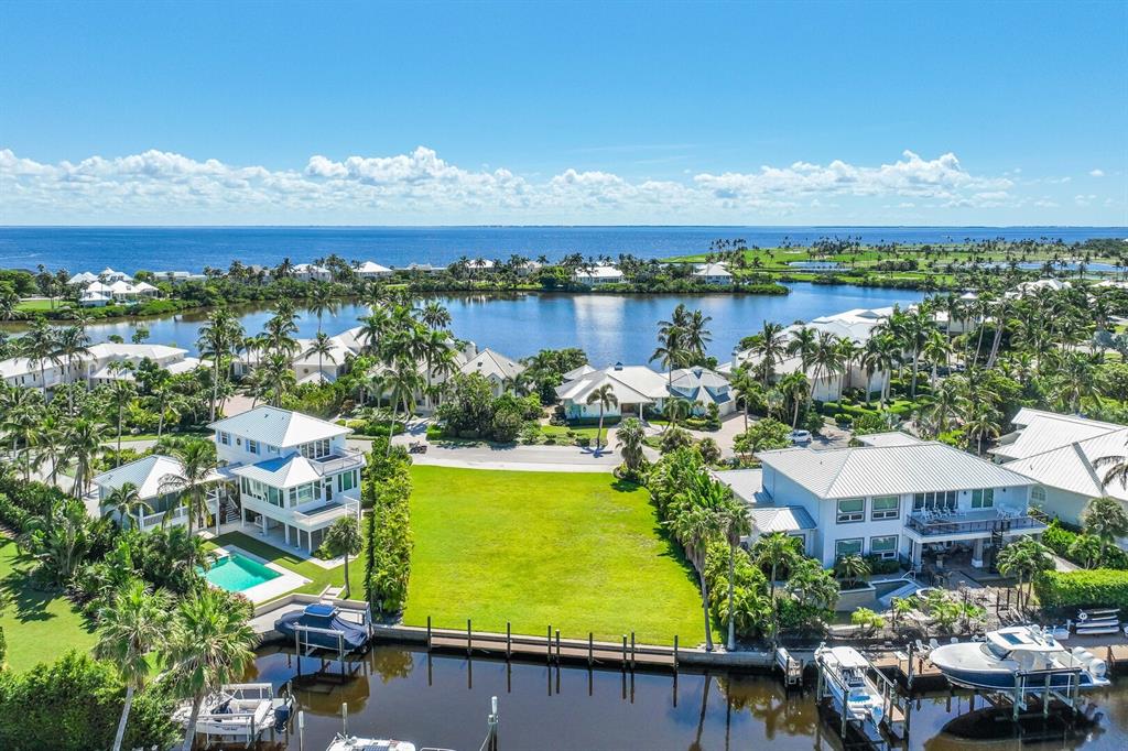An aerial view shows a vacant waterfront lot situated between two houses with private docks — 1639 JEAN LAFITTE DRIVE, BOCA GRANDE, FL