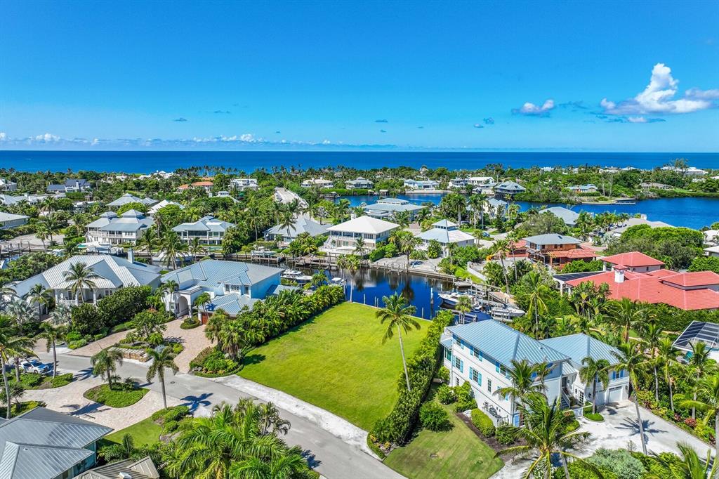An aerial view shows a vacant waterfront lot surrounded by luxury homes and tropical landscaping — 1639 JEAN LAFITTE DRIVE, BOCA GRANDE, FL