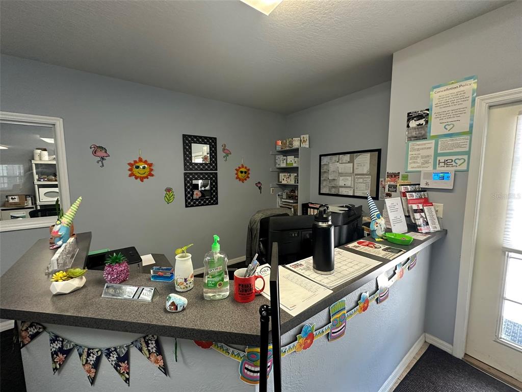 A reception desk with office supplies and decorations sits in a room with gray walls — 10960 SHELDON ROAD, TAMPA, FL