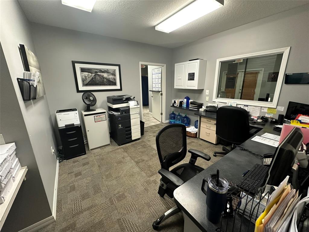 An office space features a desk, office chairs, a printer, and a window — 10960 SHELDON ROAD, TAMPA, FL
