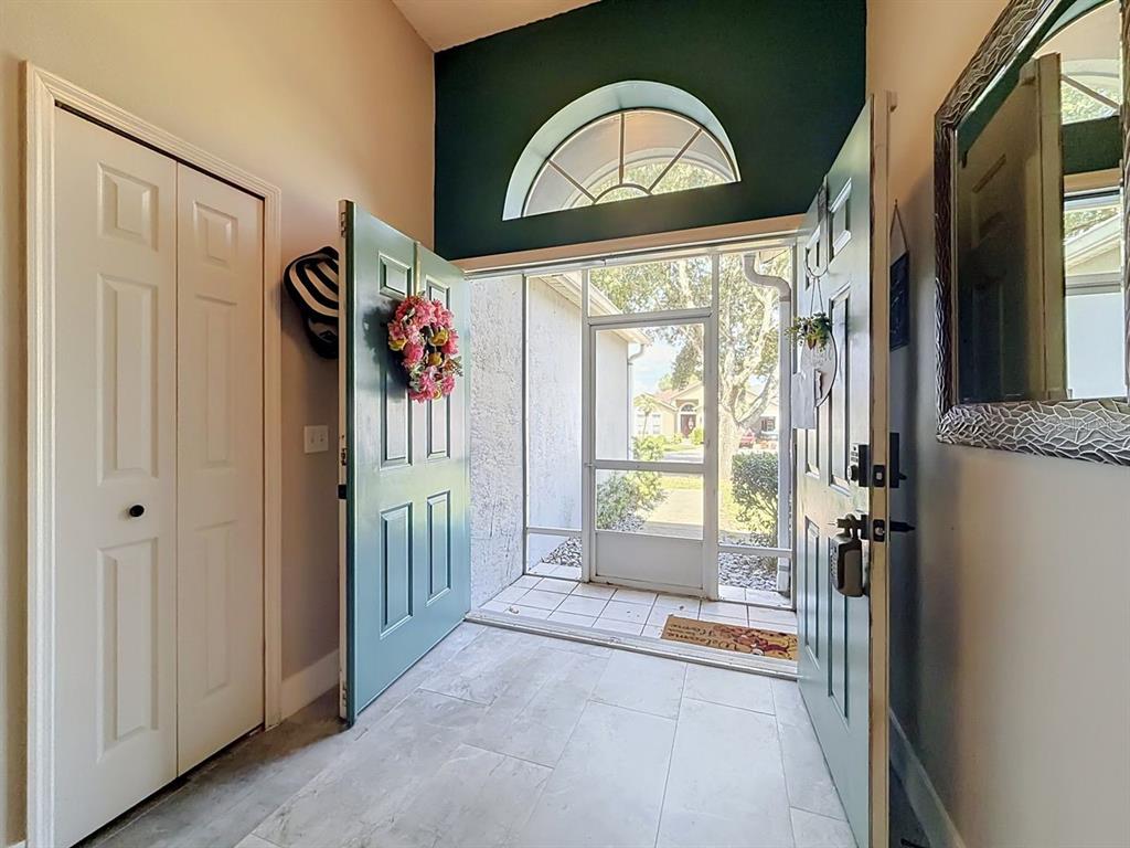 An entryway features light-colored tile flooring, a screen door, and a light blue front door — 527 DOMINISH ESTATES DRIVE, APOPKA, FL