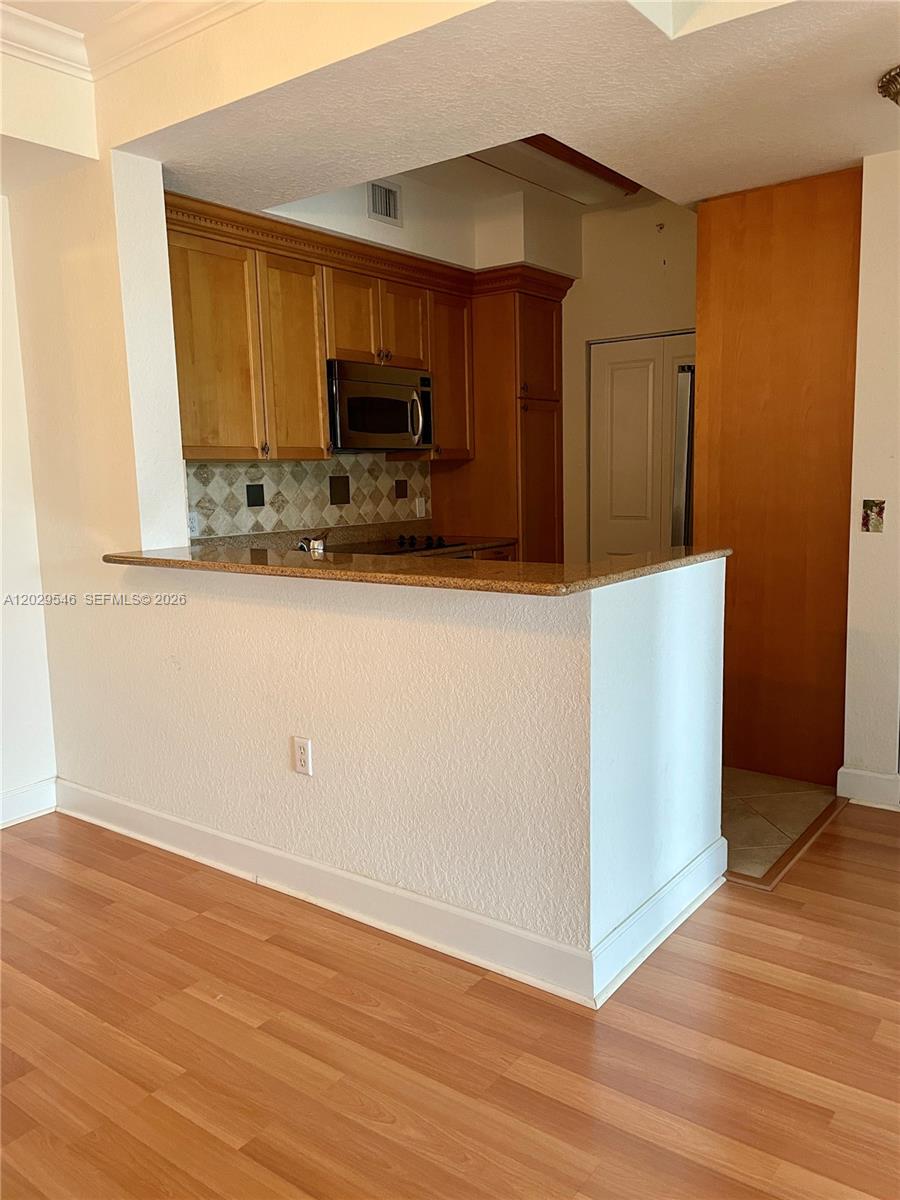 A kitchen features wood cabinets, a granite countertop, and a breakfast bar — 4408 Renaissance Way # 408, Boynton Beach FL 33426, BOYNTON BEACH, FL