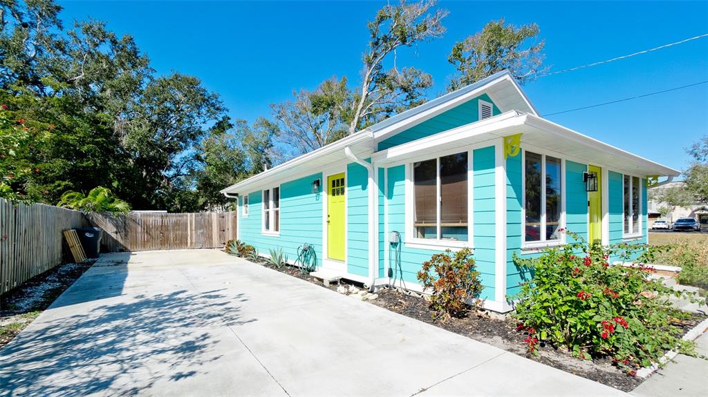 A turquoise house with a concrete driveway and two bright yellow doors — 522 37TH STREET W, BRADENTON, FL