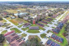 An aerial view shows a residential neighborhood with several single-story buildings and a red arrow — 858 FOX LAKE DRIVE UNIT 858, LAKELAND, FL