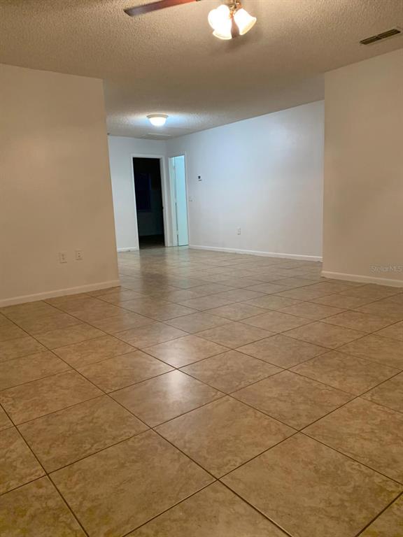 An interior view shows a room with light-colored tile flooring and white walls — 858 FOX LAKE DRIVE UNIT 858, LAKELAND, FL