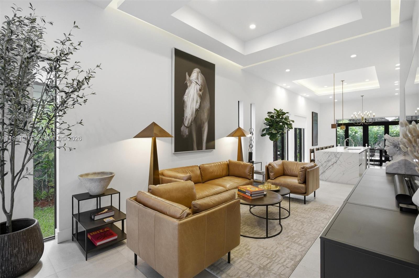 A modern living room features tan leather furniture, a large horse portrait, and marble kitchen island — 22900 SW 122 PL, Miami FL 33170, MIAMI, FL