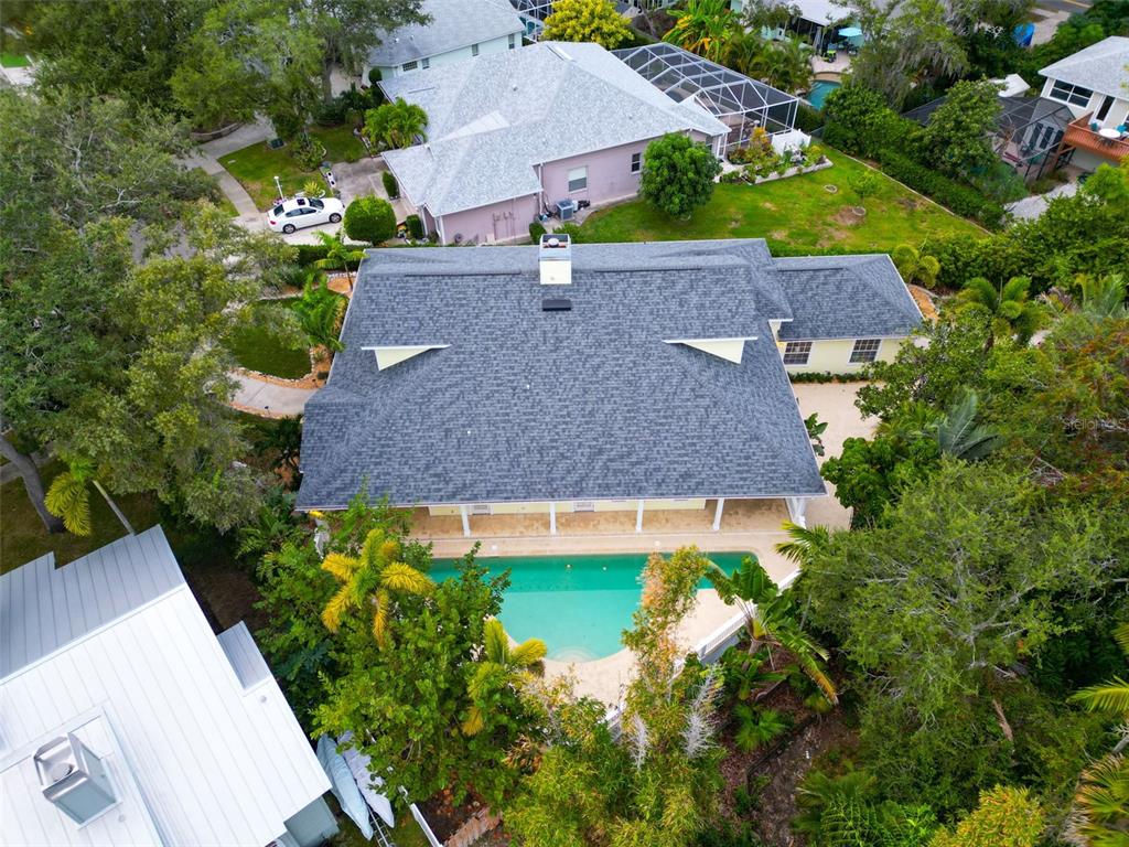 An aerial view shows a house with a gray shingled roof and a backyard pool — 266 FLORIDA BOULEVARD, CRYSTAL BEACH, FL