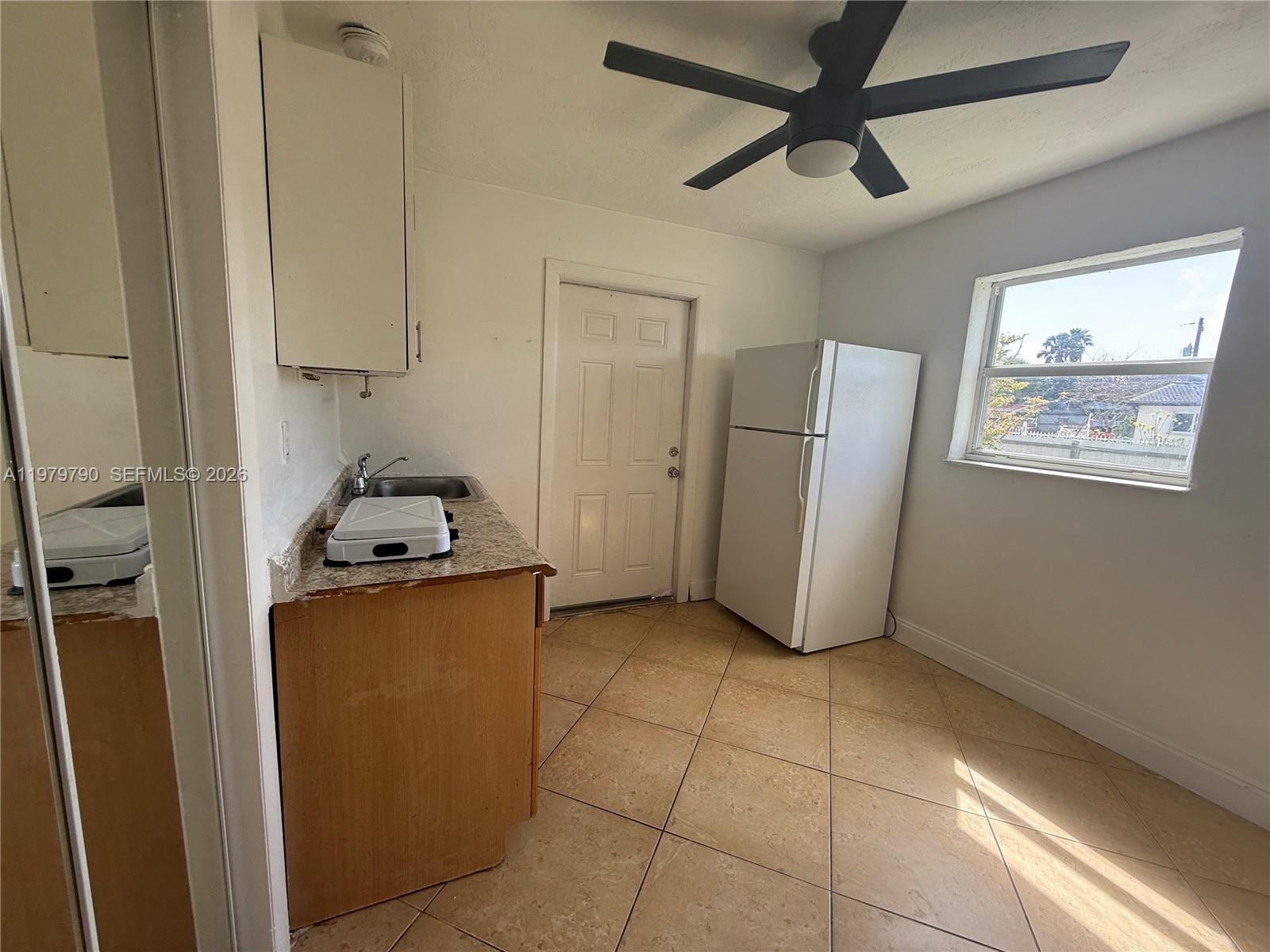 A small kitchen features a sink, a refrigerator, a ceiling fan, and tiled floors — 20221 SW 112th Ct # 2, Miami FL 33189, MIAMI, FL