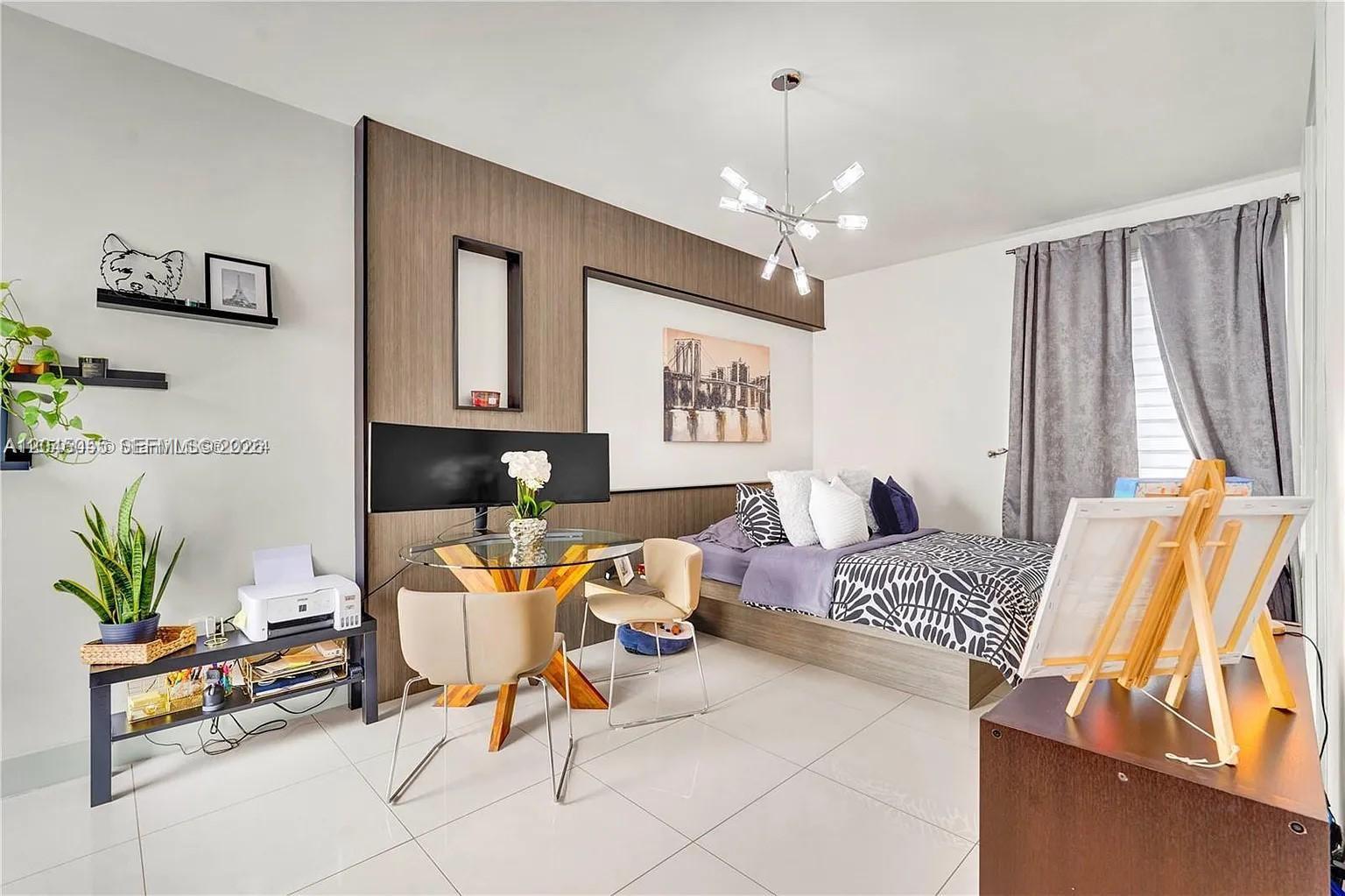 A bedroom features a platform bed, a glass-topped dining table, and a wood-paneled accent wall — 6319 NW 105 CT # 0, Doral FL 33178, DORAL, FL
