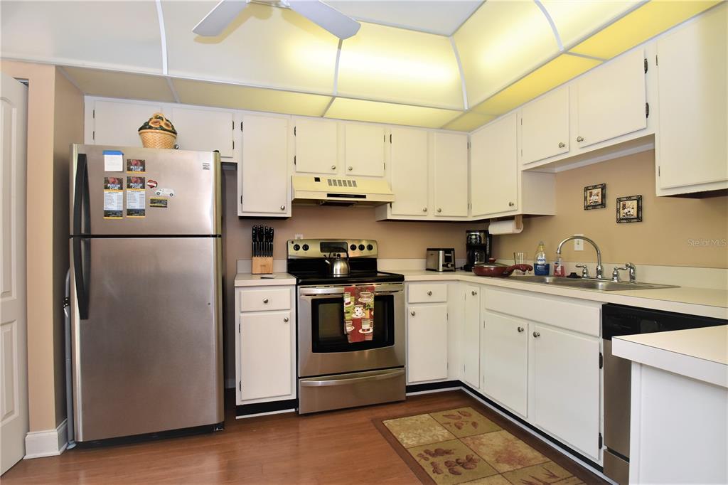 A kitchen with white cabinets, stainless steel appliances, and a light-colored countertop — 1637 BROOKHOUSE COURT UNIT BR243, SARASOTA, FL
