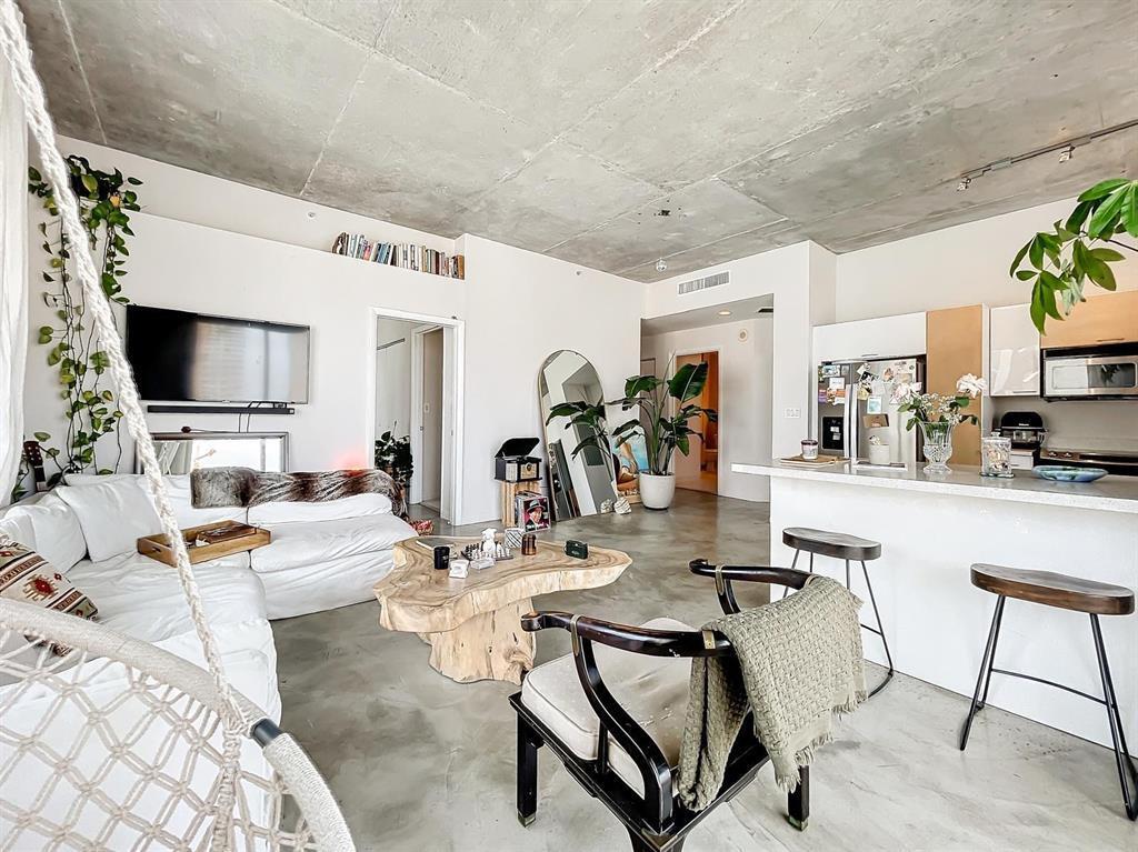 An open-concept living room and kitchen feature concrete ceilings, concrete floors, and modern furnishings — 234 NE 3rd Street # 1901, Miami FL 33132, MIAMI, FL