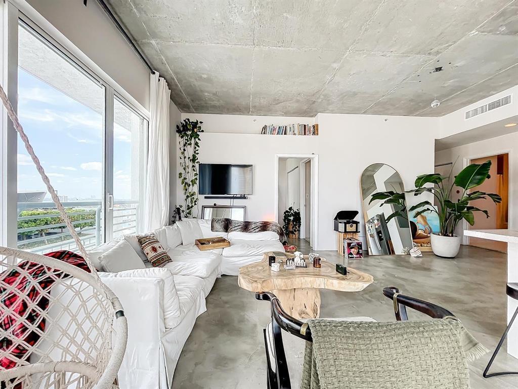 A living room with a white sectional, live-edge coffee table, and exposed concrete ceiling — 234 NE 3rd Street # 1901, Miami FL 33132, MIAMI, FL