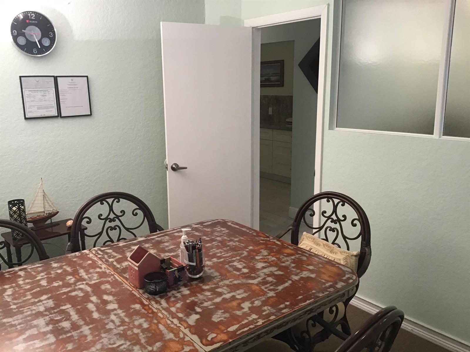 A dining room features a distressed wooden table, ornate chairs, and a doorway to another room — 812 SE 8th Avenue, Deerfield Beach FL 33441, DEERFIELD BEACH, FL