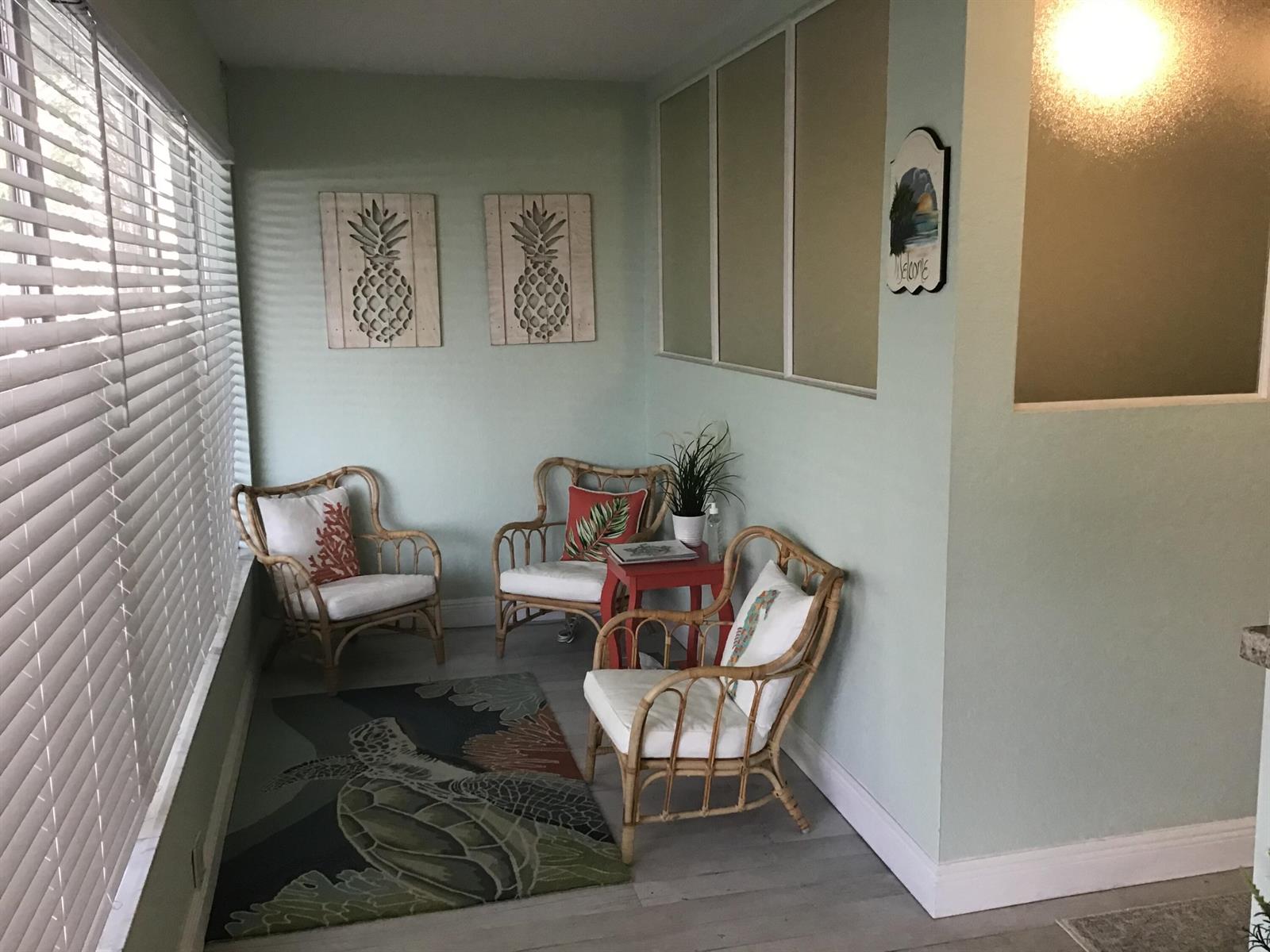 A sunroom features three rattan chairs, a small red table, and a sea turtle rug — 812 SE 8th Avenue, Deerfield Beach FL 33441, DEERFIELD BEACH, FL
