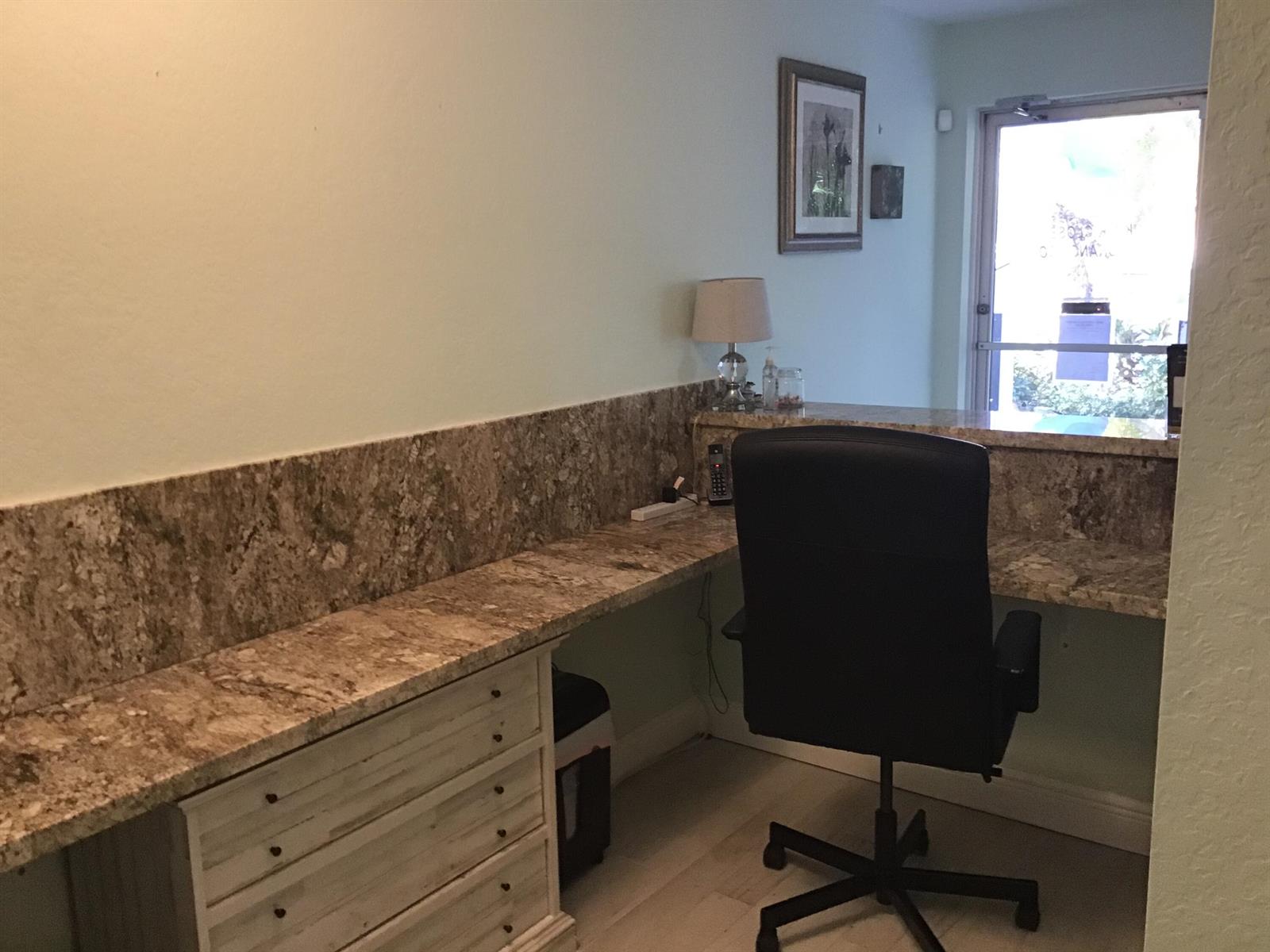 A home office features a granite countertop desk, a black chair, and a windowed door — 812 SE 8th Avenue, Deerfield Beach FL 33441, DEERFIELD BEACH, FL