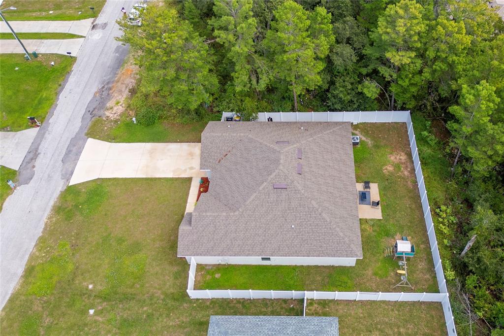 An aerial view shows a house with a shingled roof, driveway, and fenced backyard — 236 ELM COURT, KISSIMMEE, FL