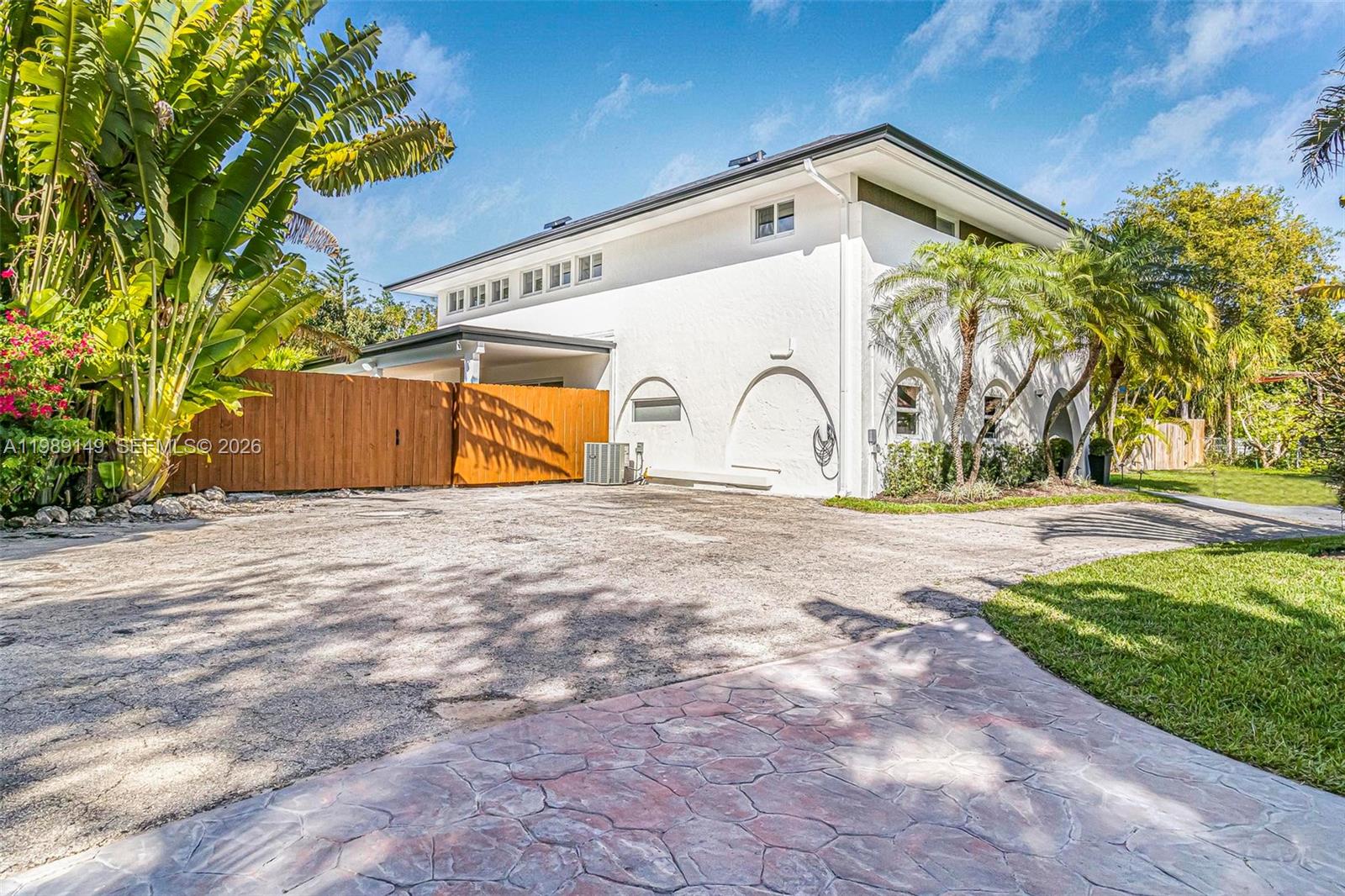 A two-story white house features arched architectural details and a large paved driveway — 18490 SW 83rd Pl, Cutler Bay FL 33157, CUTLER BAY, FL