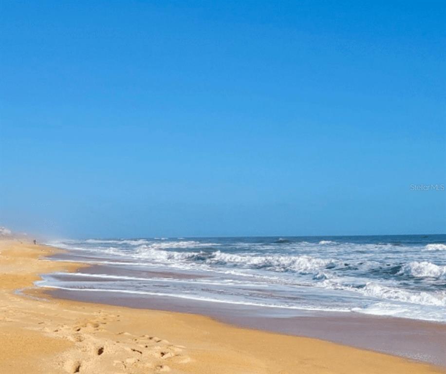 A sandy beach stretches along the ocean under a clear blue sky — 52 OCEAN RIDGE BOULEVARD N, PALM COAST, FL