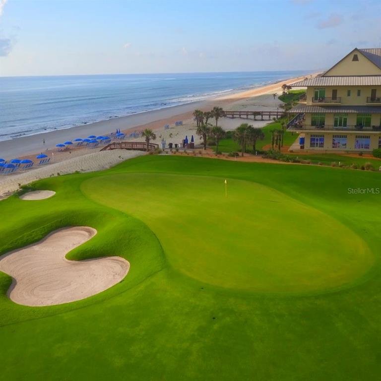 An aerial view of a golf course green situated next to a beach and building — 52 OCEAN RIDGE BOULEVARD N, PALM COAST, FL