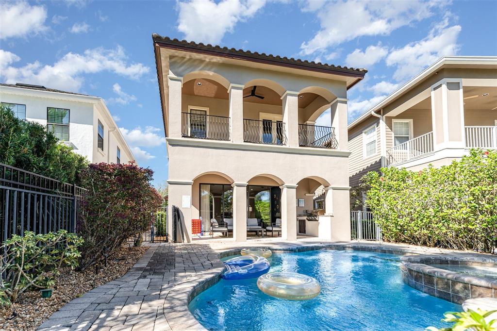 A two-story house exterior features a covered patio, balcony, and a private swimming pool — 1025 CASTLE PINES COURT, REUNION, FL