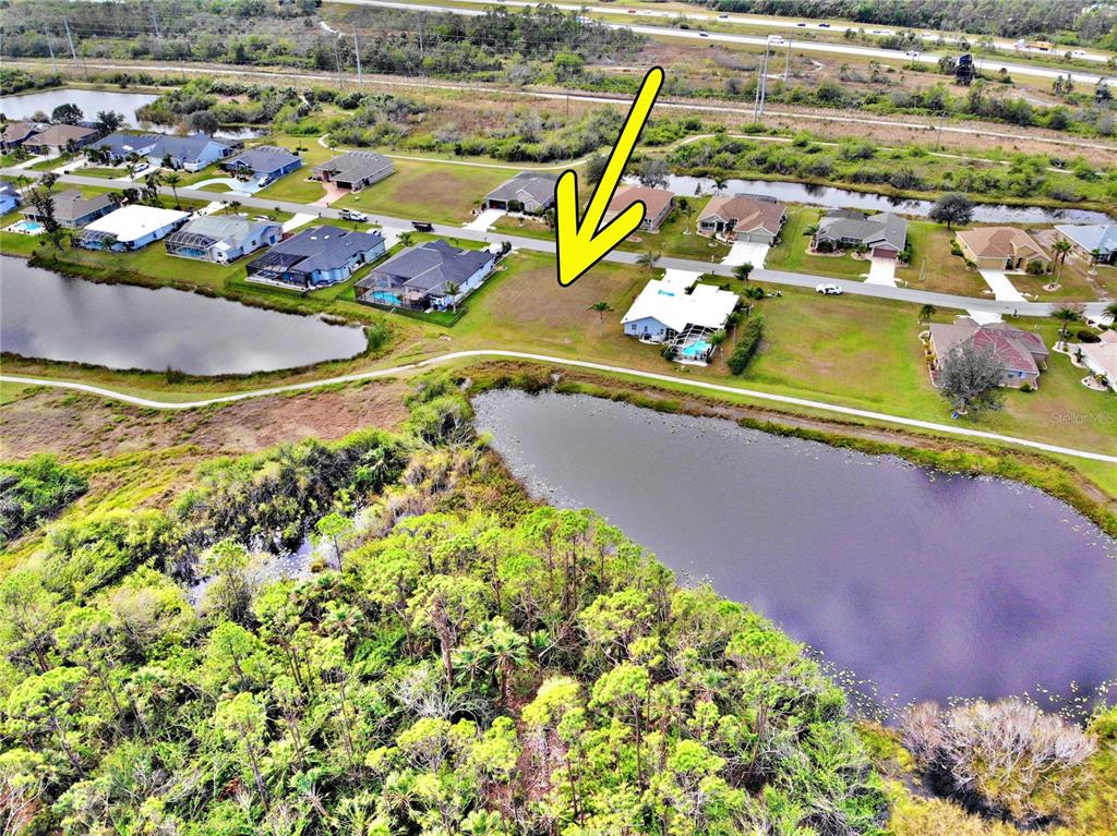 An aerial view shows a vacant residential lot next to a house with a pool — 12932 SW PEMBROKE CIRCLE S, LAKE SUZY, FL