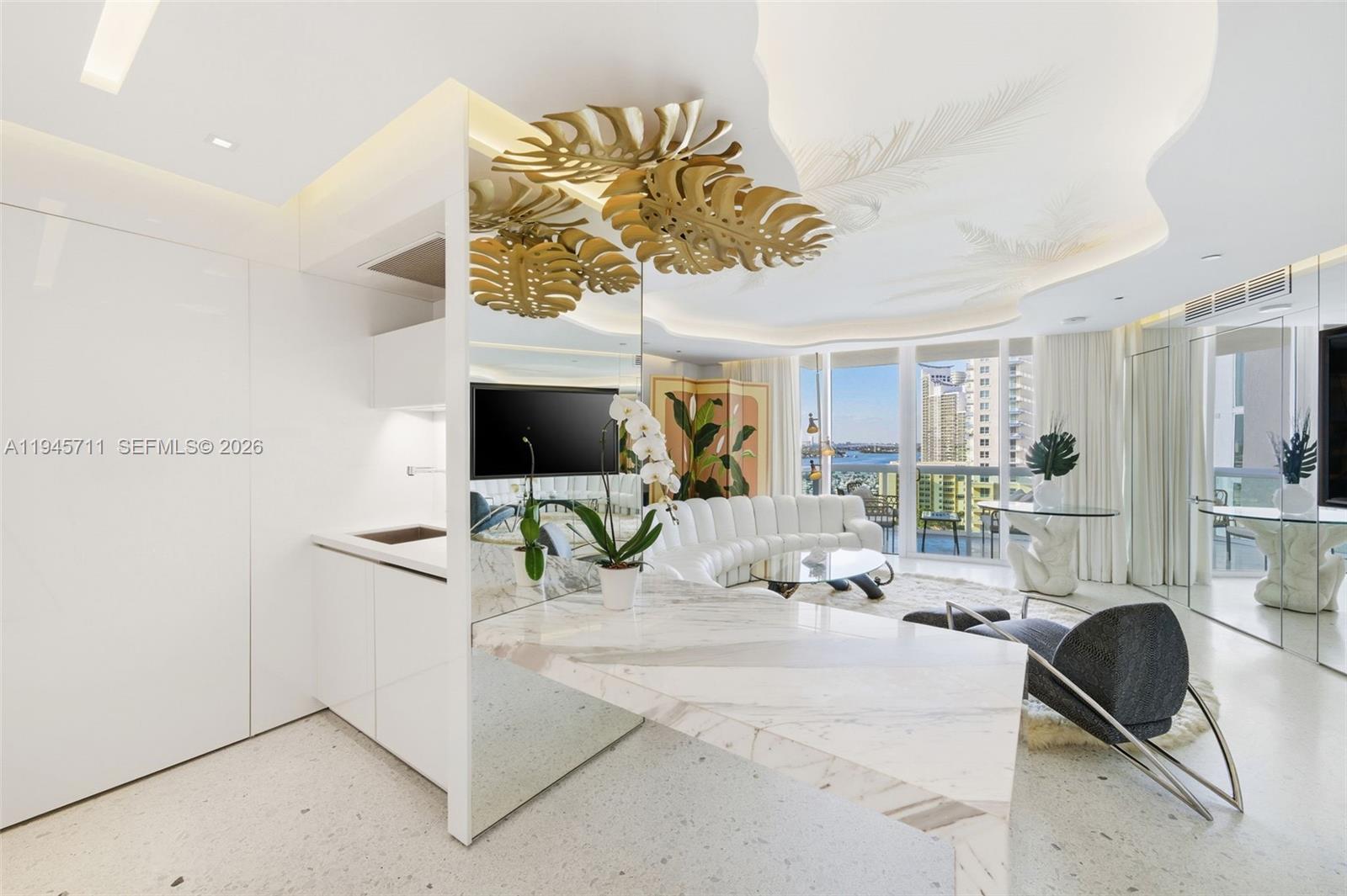 A modern living room features a marble island, curved white sofa, and gold leaf ceiling decor — 1000 S Pointe Dr # 1606, Miami Beach FL 33139, MIAMI BEACH, FL