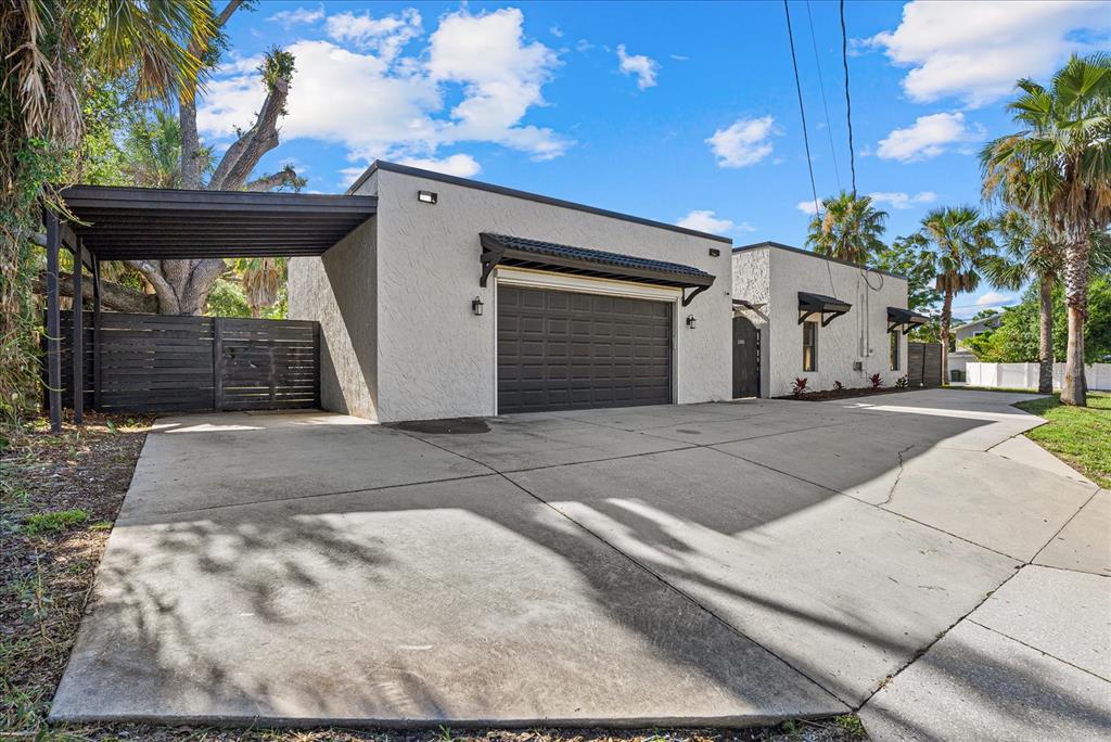 A detached garage with a carport and a concrete driveway under a blue sky — 1185 S SHADE AVENUE, SARASOTA, FL