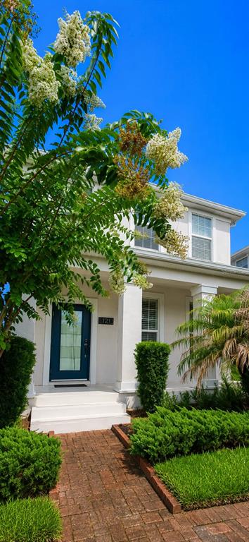 A white house with a blue front door and a brick walkway under a blue sky — 12156 PHILOSOPHY WAY, ORLANDO, FL