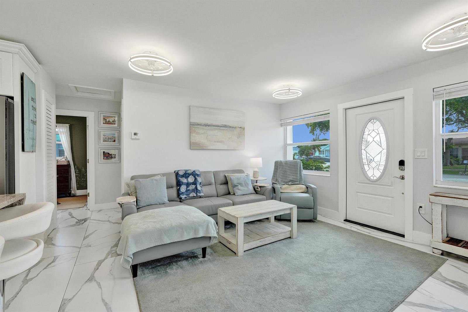 A living room features a gray sectional sofa, white coffee table, and white marble flooring — 9446 Birmingham Drive, Palm Beach Gardens FL 33410, PALM BEACH GARDENS, FL