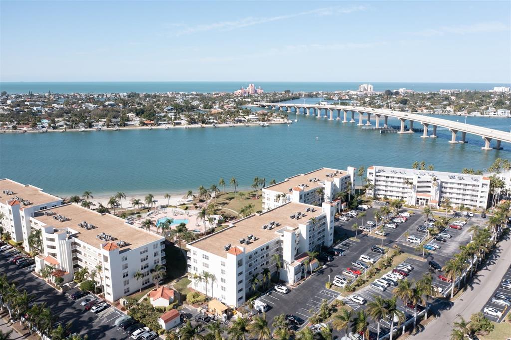 An aerial view shows multi-story apartment buildings with parking lots near a bridge and water — 5901 BAHIA DEL MAR CIRCLE UNIT 124, ST PETERSBURG, FL