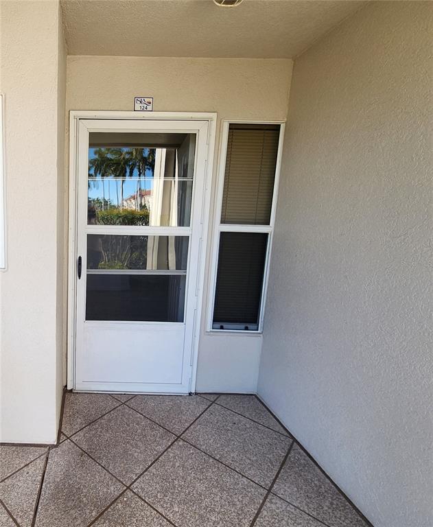 A white storm door and a side window are located on a tiled entryway — 5901 BAHIA DEL MAR CIRCLE UNIT 124, ST PETERSBURG, FL
