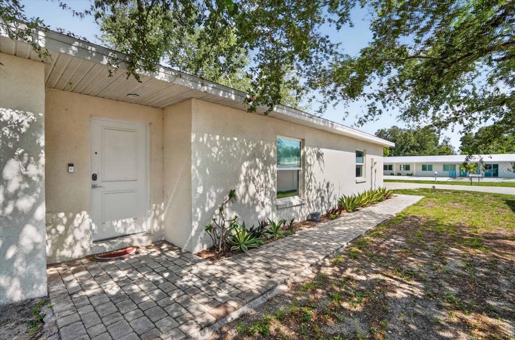 A paved walkway leads to the front entrance of a single-story stucco house — 2011 OUTER DRIVE UNIT 1, SARASOTA, FL