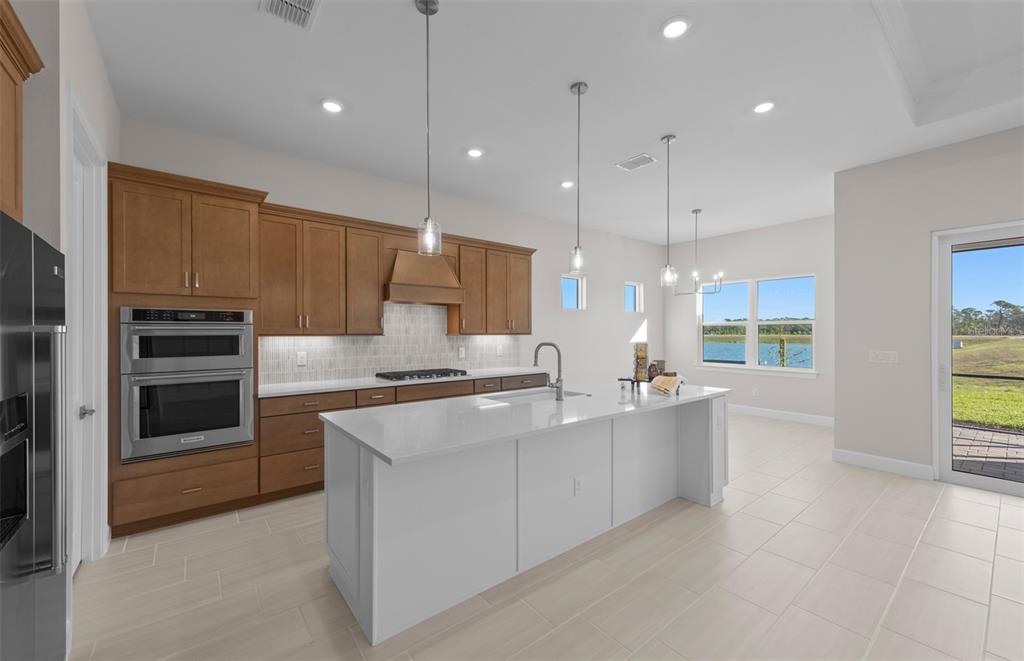 A kitchen with wood cabinets, a white island, stainless steel appliances, and a water view — 1835 SILVER SHORES BOULEVARD, ENGLEWOOD, FL