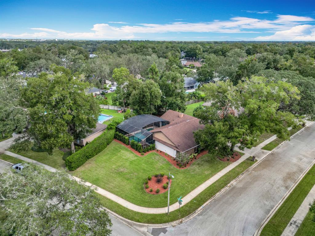 An aerial view shows a single-story house with a screened pool on a corner lot — 1469 GRACE LAKE CIRCLE, LONGWOOD, FL