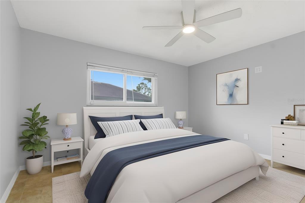 A bedroom features a bed with blue and white bedding, a ceiling fan, and furniture — 2701 COUNTRYSIDE BOULEVARD UNIT 102, CLEARWATER, FL