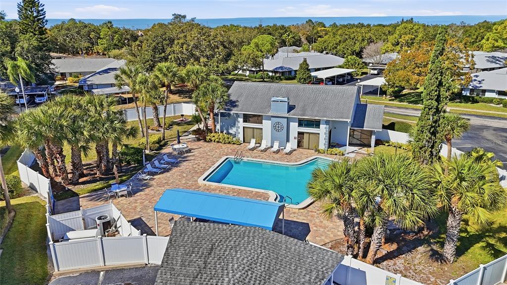 An aerial view shows a community swimming pool with a blue canopy and surrounding patio — 2701 COUNTRYSIDE BOULEVARD UNIT 102, CLEARWATER, FL