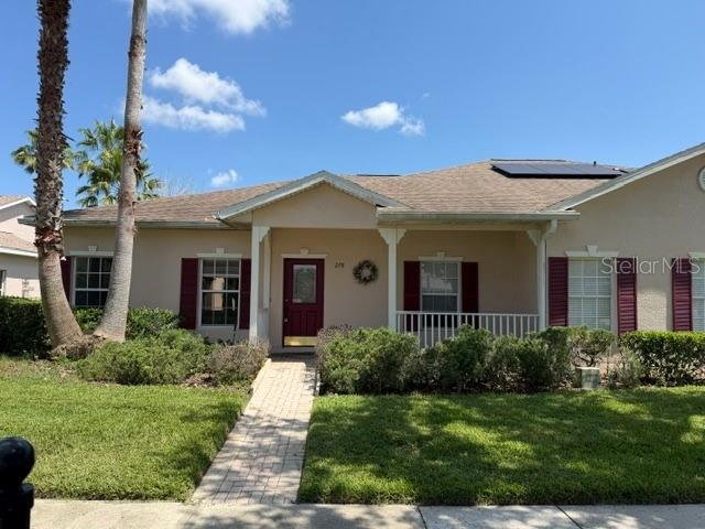 A single-story house with a tan exterior, a red front door, and a paved walkway — 278 ANASTASIA DRIVE, KISSIMMEE, FL