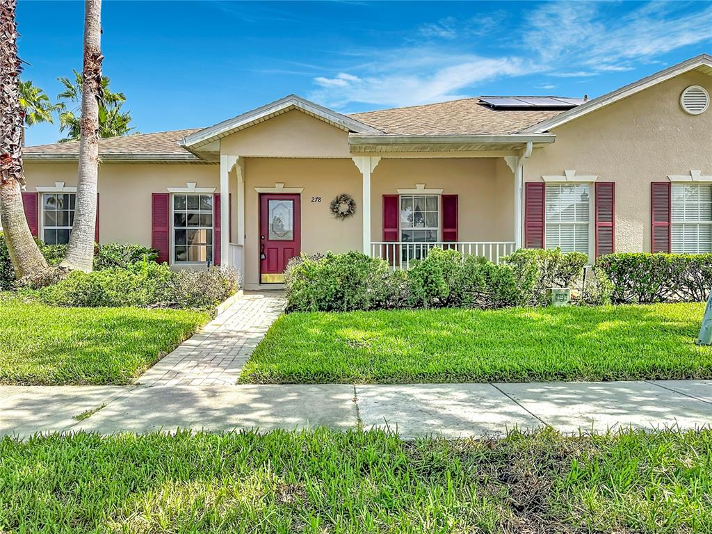 A single-story house with a tan stucco exterior, red shutters, and a front walkway — 278 ANASTASIA DRIVE, KISSIMMEE, FL