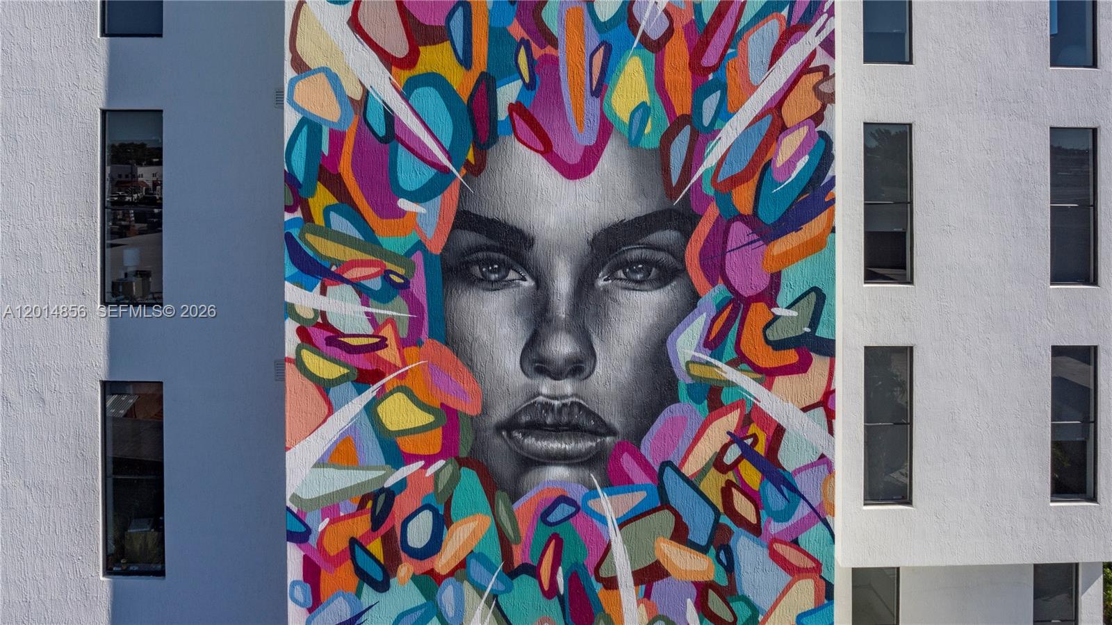 A large, colorful mural of a woman's face is painted on the exterior of a building — 6970 SW 40th St # 302, Miami FL 33155, MIAMI, FL