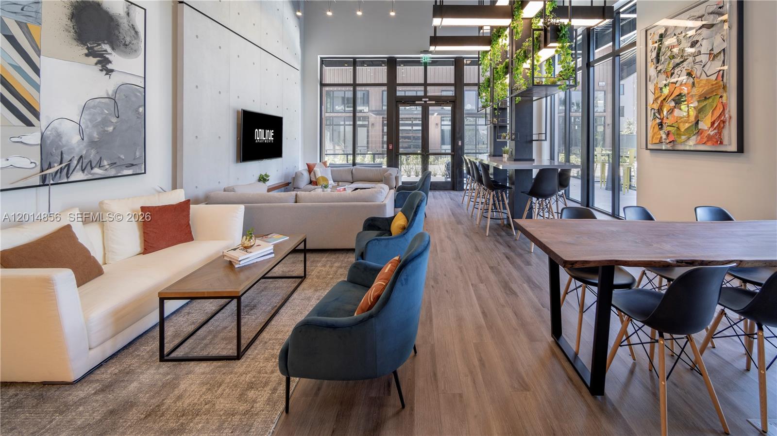 A modern apartment lounge features a seating area, a dining table, and bar stools — 6970 SW 40th St # 302, Miami FL 33155, MIAMI, FL