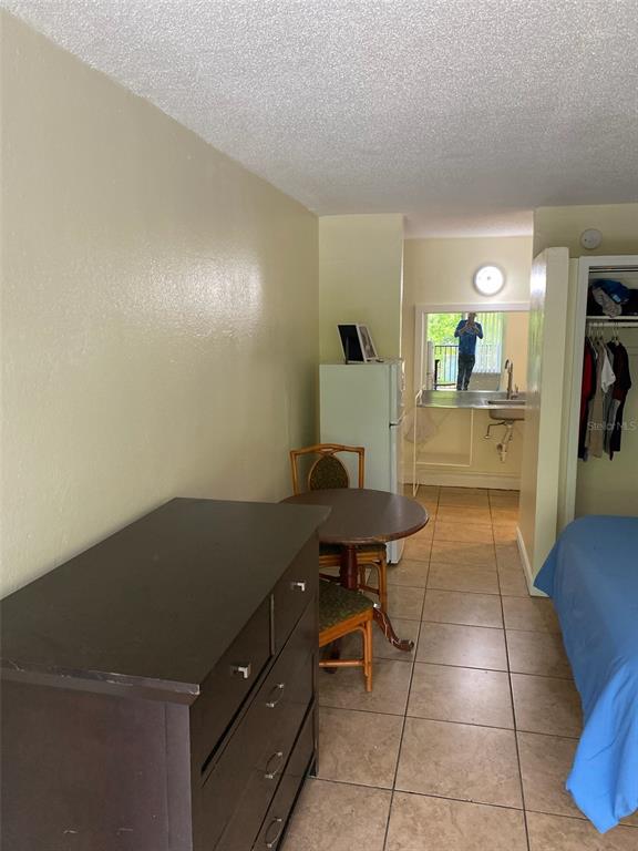 A studio apartment features a dresser, a small dining table, a kitchenette, and a bed — 7900 S ORANGE BLOSSOM TRAIL UNIT 2123, ORLANDO, FL