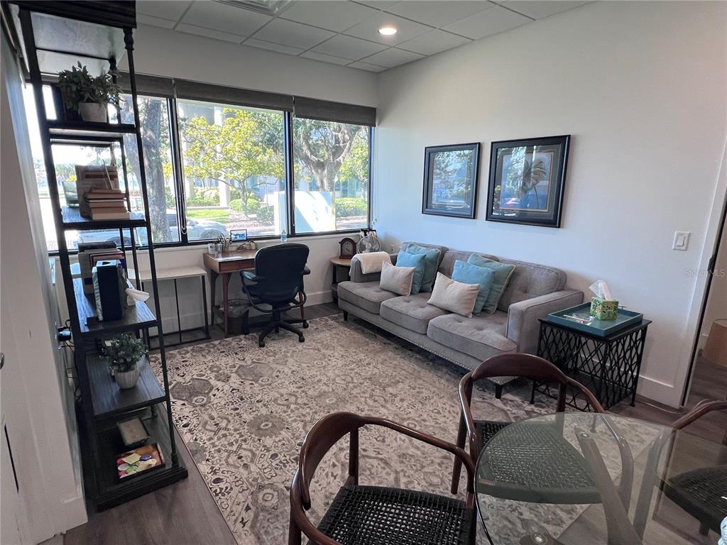 A furnished office space features a gray sofa, a desk, and a glass table — 515 W BAY STREET UNIT 100, 101, TAMPA, FL