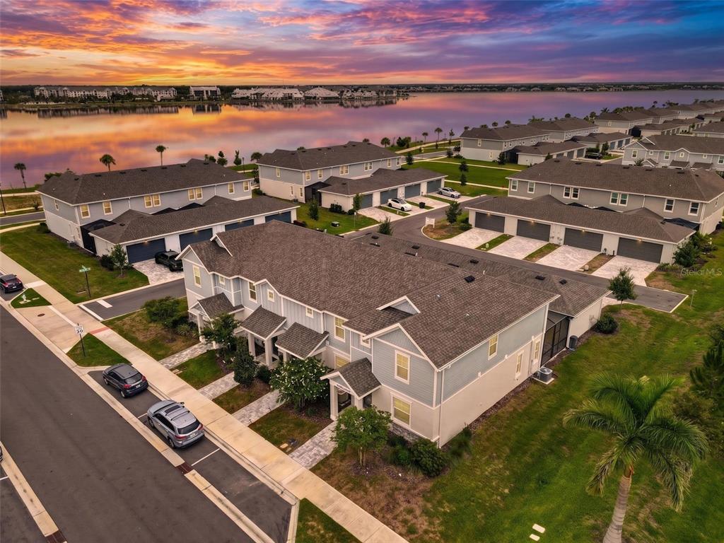 An aerial view shows a multi-unit residential building with a lake in the background — 1813 FENDER LANE, SARASOTA, FL